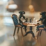 people sitting on chair in front of table while holding pens during daytime